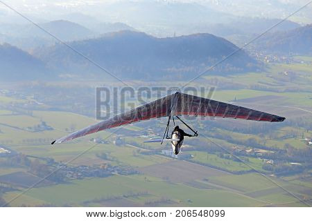 Man Flying High With His Hang Glider Above The Plain