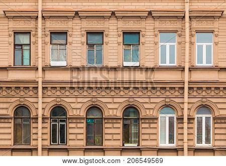 Several windows in a row on facade of urban apartment building front view St. Petersburg Russia