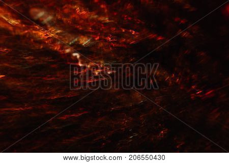 Abstract background of colorful crankles in motion on black. Bokeh of defocused curves, blurred neon yellow and red leds, hellfire and smoke, abyss and seven circles of hell