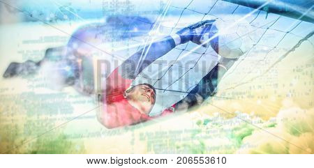 Goalkeeper in red jumping up to save a goal against virtual reality headset on table