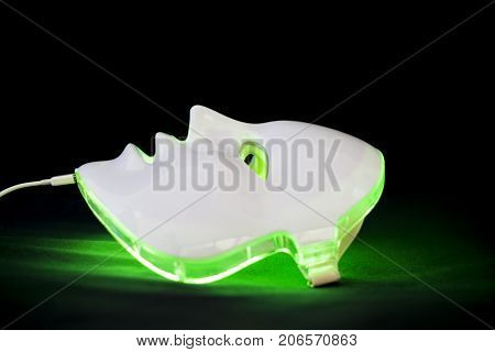 Light rejuvenating mask for facial skin therapy on black background