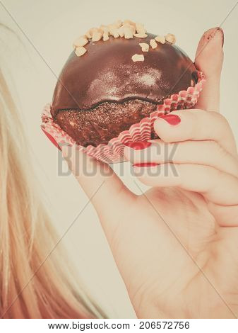 Woman Hand Holding Chocolate Cupcake About To Bite
