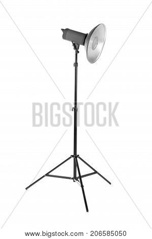 Professional photo studio flashlight isolated over the white background. Photographic light on a long tripod. A reflector and outbreak on a tripod. Dark black photo equipment.