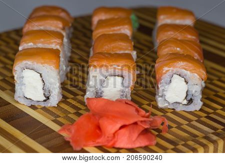 The set of philadelphia salmon rolls on bamboo board. Side view