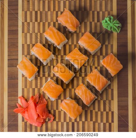 The set of salmon rolls on bamboo board. View from above.