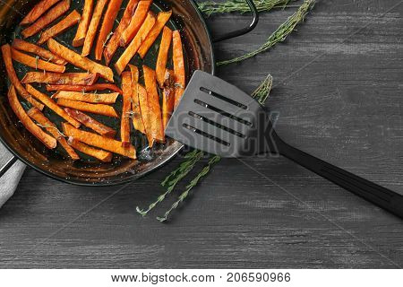 Frying pan with sweet potato fries on table