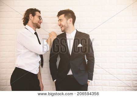 Two young smart businessmen talking together during leisure time at indoor. Business teamwork and coworker concept Relax concept. Soft tone pinterest and instragram like process.