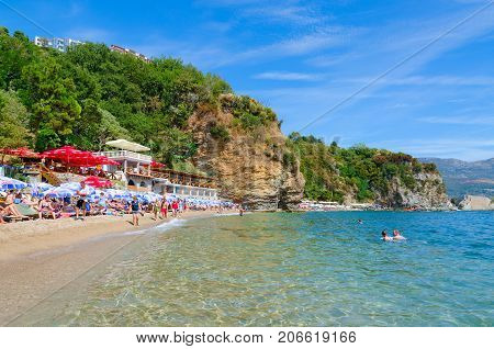 BUDVA MONTENEGRO - SEPTEMBER 7 2017: Unknown people rest on popular beach Mogren 2 in resort town of Budva Montenegro