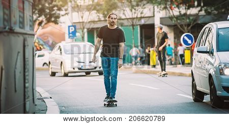 Two Pro Skateboard Rider Ride Skate Through Cars On Street