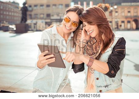 Young woman friends using tablet and listening music from tablet ,technology concept.