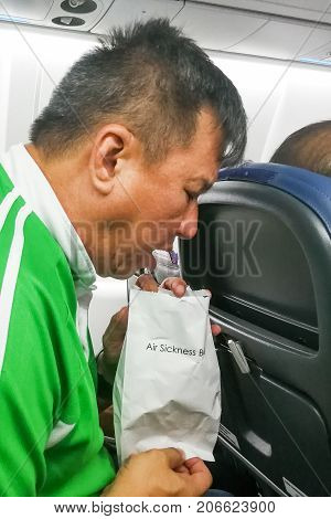 Nauseous Air Sickness Asian Man Vomiting Into Air Sickness Bag
