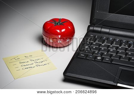 Tomato-shaped kitchen timer set at 25 minutes to fight procrastination in studying and working.