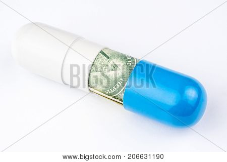 One Dollar Banknote Is Rolled Into A Big Blue And White Capsule Looking Like A Big Pill