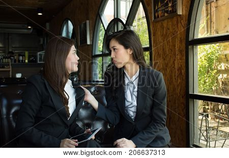 Portrait of Aggressive young Asian woman in formal wear or businesswoman fight in coffee shop/Two business woman have problem conflict, fighting, try to knock other one out