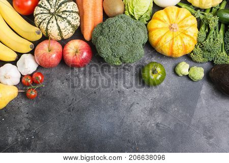 Table top view of different rainbow vegetables and fruits on the light grey background, copy space for text below, selective focus