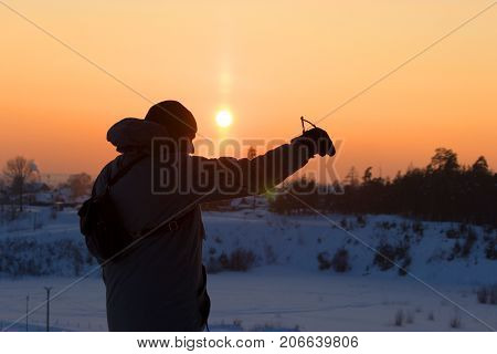Young man playing with his dog. back lit