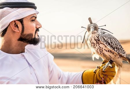 Arabian man walking in the desert at sunrise