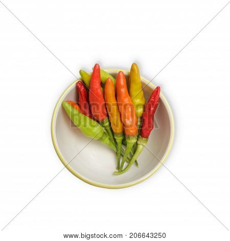 A bowl of different colors of chilli peppers isolated on white background with clipping path.