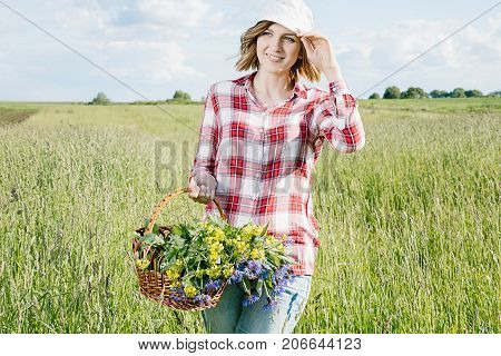 Girl With A Basket Of Flowers In The Field.