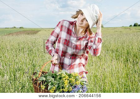 Girl With A Basket Of Flowers In The Field.