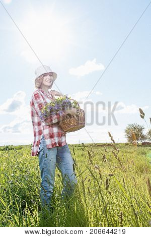 Girl With A Basket Of Flowers In The Field.
