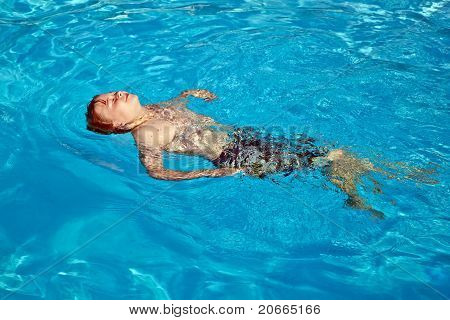 niño tiene diversión en la piscina al aire libre