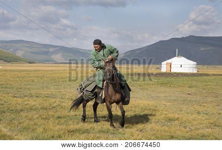 Huvsgul Mongolia September 6th 2017: mongolian man riding a horse in northern mongolian landscape