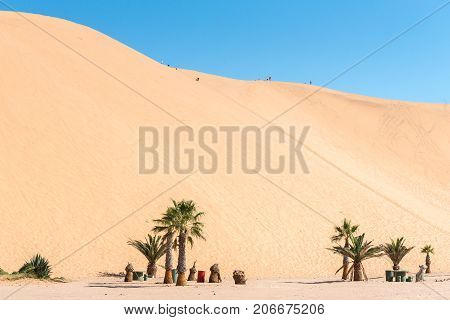 WALVIS BAY NAMIBIA - JULY 2 2017: Picnic spots and unidentified tourists on dune 7 at Walvis Bay in the Namib Desert on the Atlantic Coast of Namibia
