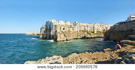 Polignano a Mare Italy - August 13 2017. Tourist in front of view of Bastione di Santo Stefano of Polignano a Mare. View from Pietra Piatta. Apulia Italy.