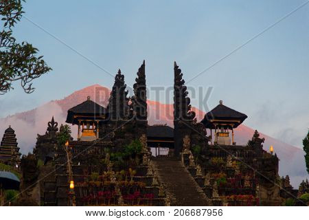 Balinese Sacred Mountain Agung Colored In Pink By Sunset Light. Main Bali Temple Pura Besakih At The