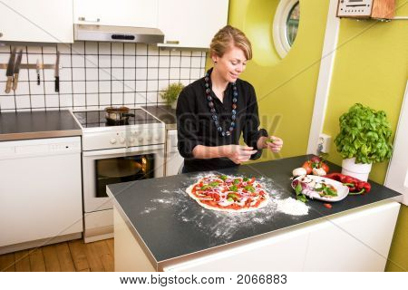 Unge kvindelige Making Pizza