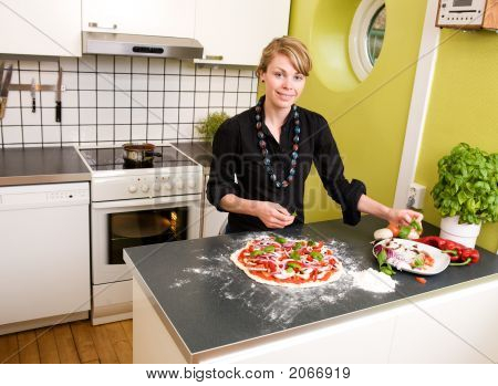 Unge kvindelige Making Pizza