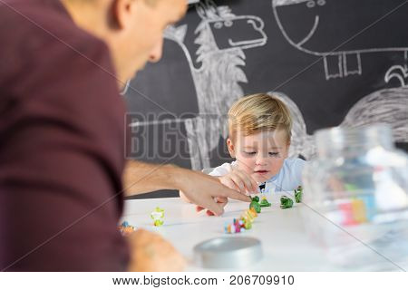Cute little playfull toddler boy at child therapy session. Private one on one homeschooling with didactic aids.