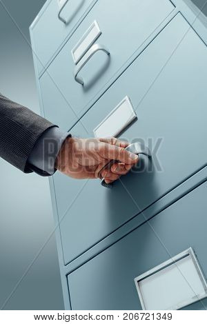 Office Clerk Searching Files In The Filing Cabinet