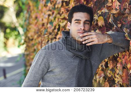 Handsome Man Wearing Winter Clothes In Wooden Background.