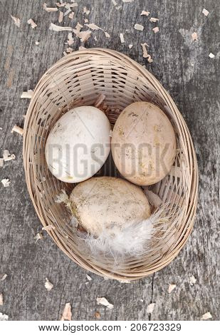 fresh eggs in a littlle basket on wooden background