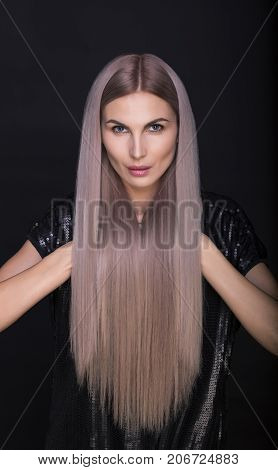 Beautiful woman with long straight trendy blonde hairs studio shot.