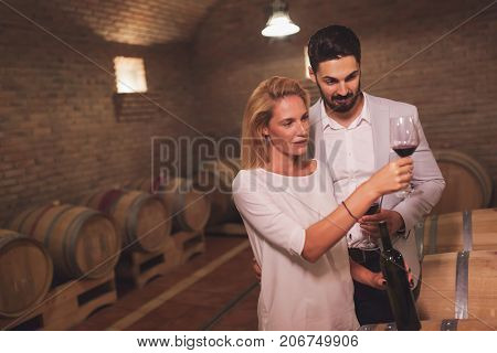 Wine loving couple tasting wines in winery cellar