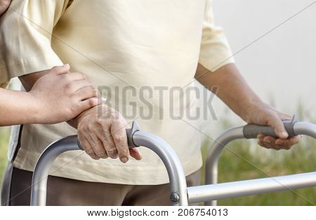 senior woman using a walker with caregiver