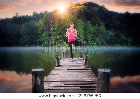 Yoga post on the wooded bridge in Pang ung park Pangung Mae Hong Son Thailand Asia