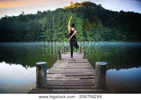 Yoga post on the wooded bridge in Pang ung park Pangung Mae Hong Son Thailand Asia