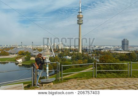 Lady tourist with backpack admiring the sights of Olympiapark on September 30 2017 in Munich Bavaria Germany.