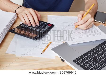 Cropped Shot Of Male Calculates, Makes Financial Report, Studies Documents, Writes With Pencil. Work