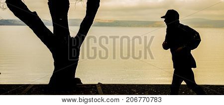 Bracciano Italy - January 31 2016: It is a very cloudy morning but this intrepid runner doesn't want to lose his workout