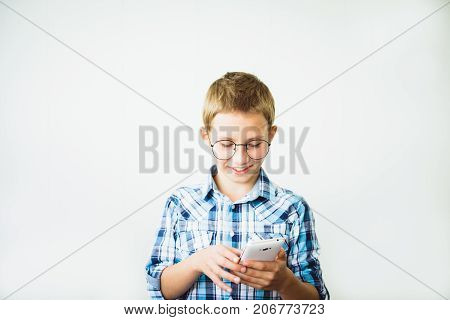 Gay boy teen in glasses smiling with smartphone. Copy space