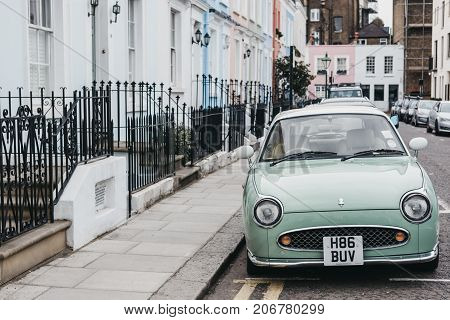 LONDON, UK - SEPTEMBER 24, 2017: Pastel blue Nissan Figaro next to pastel houses in Notting Hill, London. Nissan Figaro was built for a short period (1991) purely for the Japanese market.
