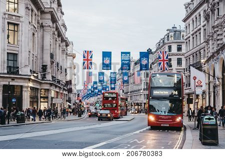 LONDON, UK - SEPTEMBER 24, 2017: Red double-decker buses on Regent Street, London. The street is decorated with NFL flags to celebrate the event and four NFL games played in capital in 2017.