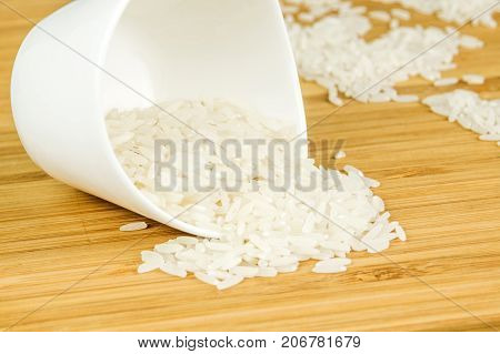 White Rice Spill Out Of Wite Ceramic Bowl