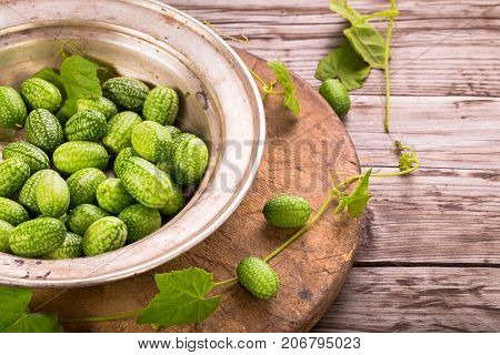 Cucamelons in plate  on rustic table with copy space
