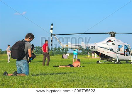 Zhytomyr Ukraine - May 05 2015: Young Man Sunbathing at helicopter starting competition while him shooting on camera